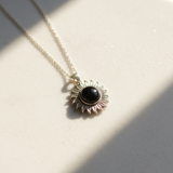 Silver sun pendant with black sandstone